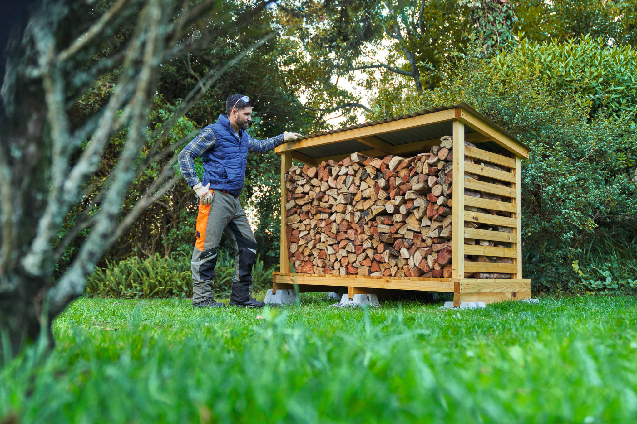 A man wearing protective equipment in front of a DIY log store