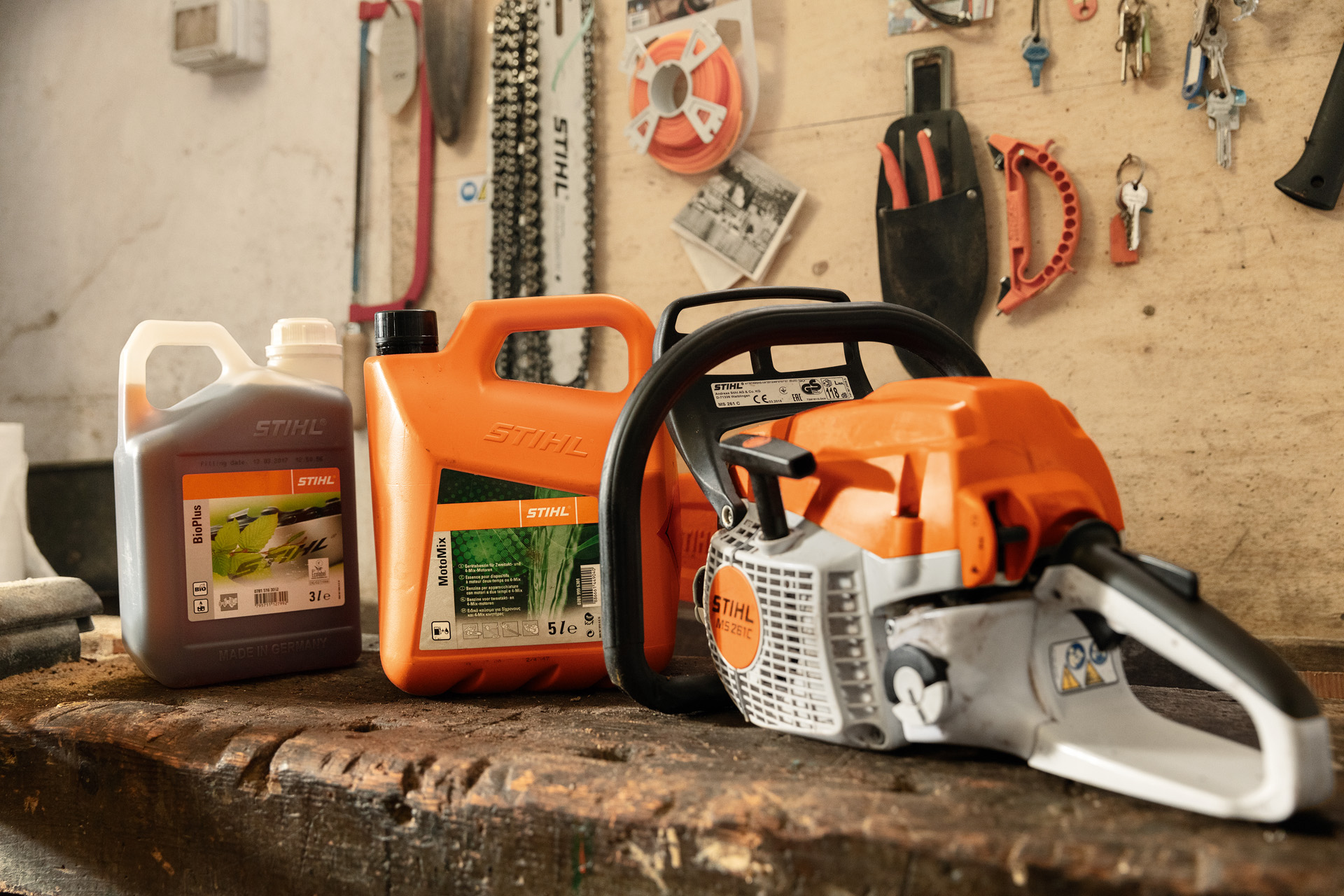 STIHL MS 261 C-BE chain saw with toolless fuel filler cap next to MotoMix and BioPlus