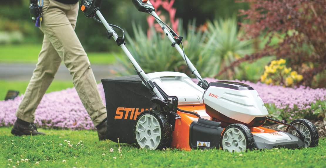 a man lawns a garden with a STIHL lawn mower