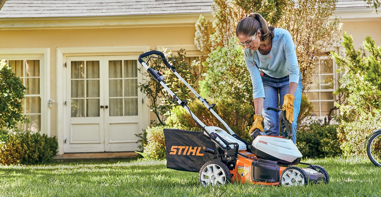 a woman uses STIHL lawn mower in her garden