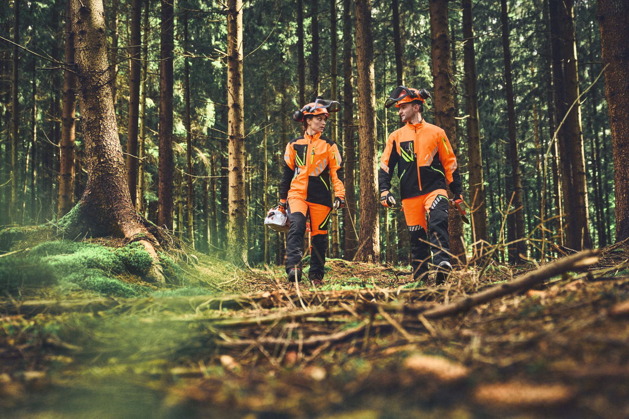 Two forestry workers with ADVANCE FlexTEC ShellTEC personal protective equipment clothing in the forest
