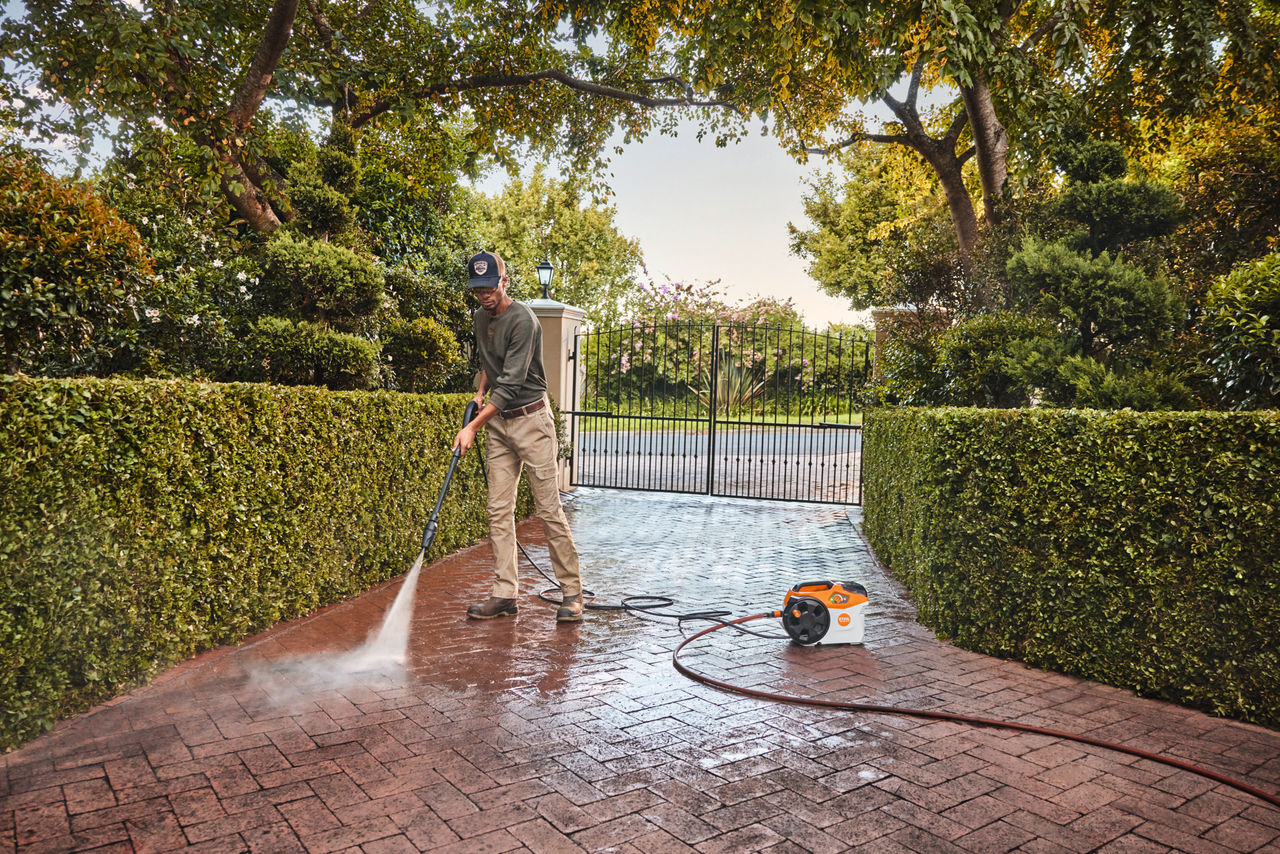 A man uses the STIHL high-pressure cleaner REA 100